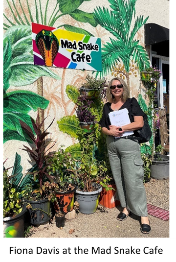 DAVLS lawyer Fiona Davis outside the Mad Snake cafe in Darwin, in front of their colourful mural of tropical plants.