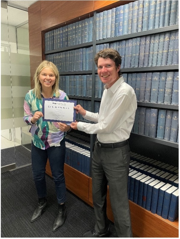 Man Michael Pagano and woman Gabrielle Karas holding a certificate of appreciation