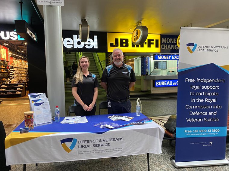 Smiling man and woman inn shopping center in front of a table with DAVLS branding