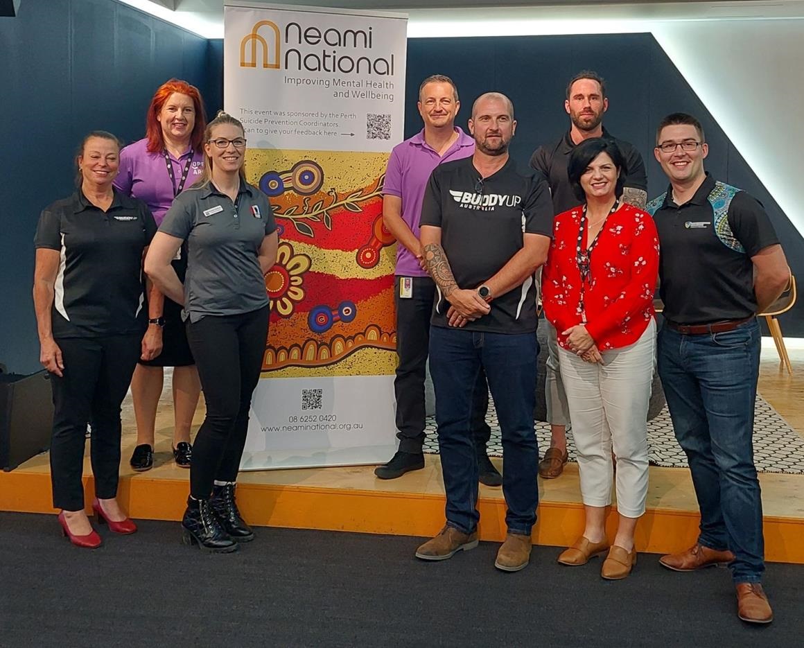 Group of people at event standing in front of sign