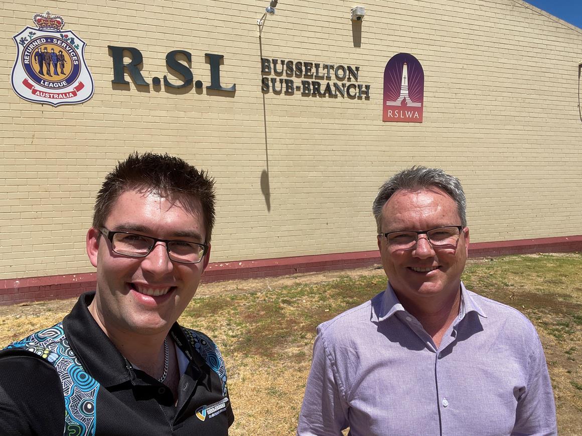 Two men standing in front of a wall saying Busselton Sub-Branch, RSL