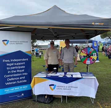 DAVLS staff at their stall under a marquee with table, banner and resources displayed